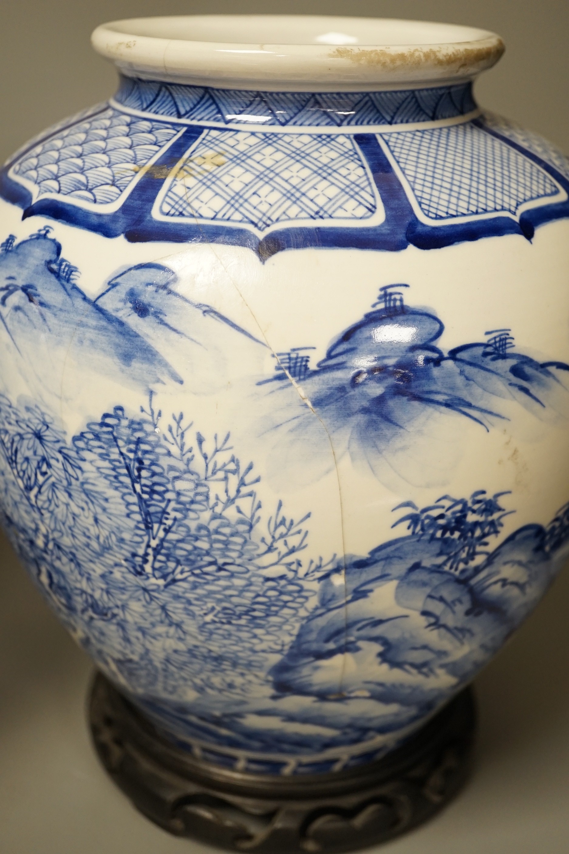 A pair of large Japanese blue and white vases, on wood stands, 26cms high of including stand.